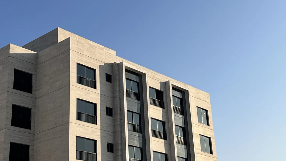 Stone-clad apartment building at Eighteen Islamabad under a clear sky