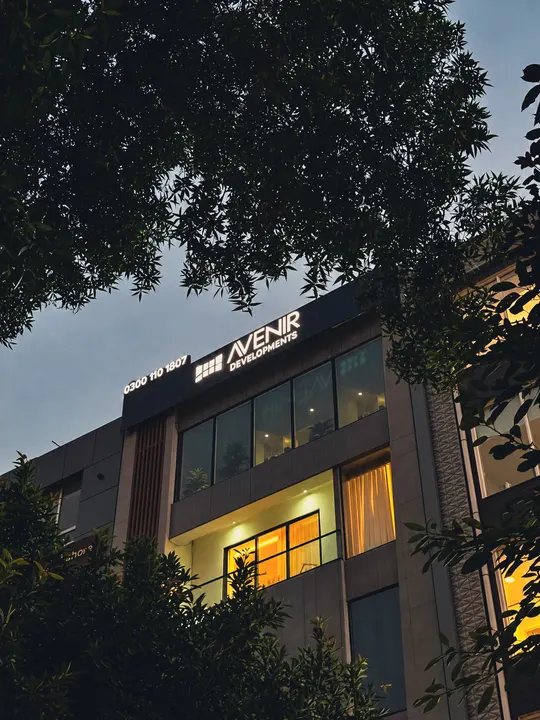 The Avenir Developments office building at 139, CCA, DHA Phase 5, Lahore, with its sign lit at dusk